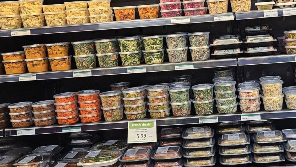wide view of deli cooler filled with containers of grab-n-go offerings