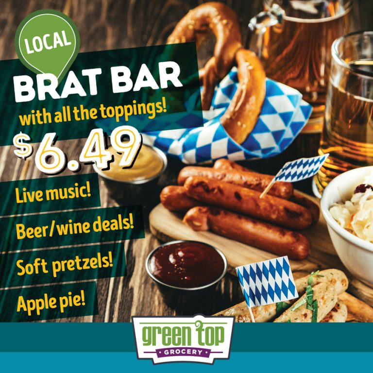 photo of blue/white checked napkins and Oktoberfest foods on a rustic tabletop. Glass of beer, soft pretzels, bratwurst on a plate with mustards